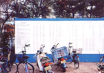 避難所となった学校の校庭。仮設住宅の申込抽選結果が掲示された(長田区・志里池小学校 1995年2月13日)