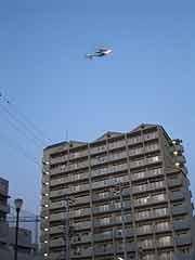 夕方の「1.17ろうそく法要」マスコミの報道ヘリ(神戸市長田区御蔵通・御蔵北公園 2003年1月17日)