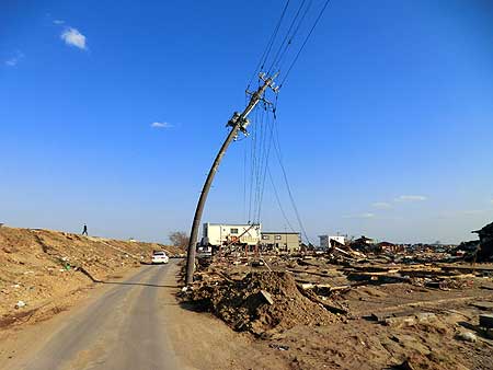阿武隈川河口を遡上した津波は、土手を越えて溢れてきた。コンクリートの電柱までも曲った。